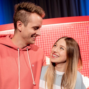 Das YouTuber-Paar Julian Claßen und Bianca Claßen schauen sich beim YouTube-Jahresrückblick 2018 im YouTube Space Berlin vor einem YouTube-Logo an.