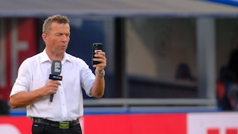 Ein Selfie muss sein! Weltmeister und TV-Experte Lothar Matthäus am 4. Juni 2022 in Bologna. Matthäus hält ein Smartphone in der linken Hand, in der rechten ein Mikrofon.
