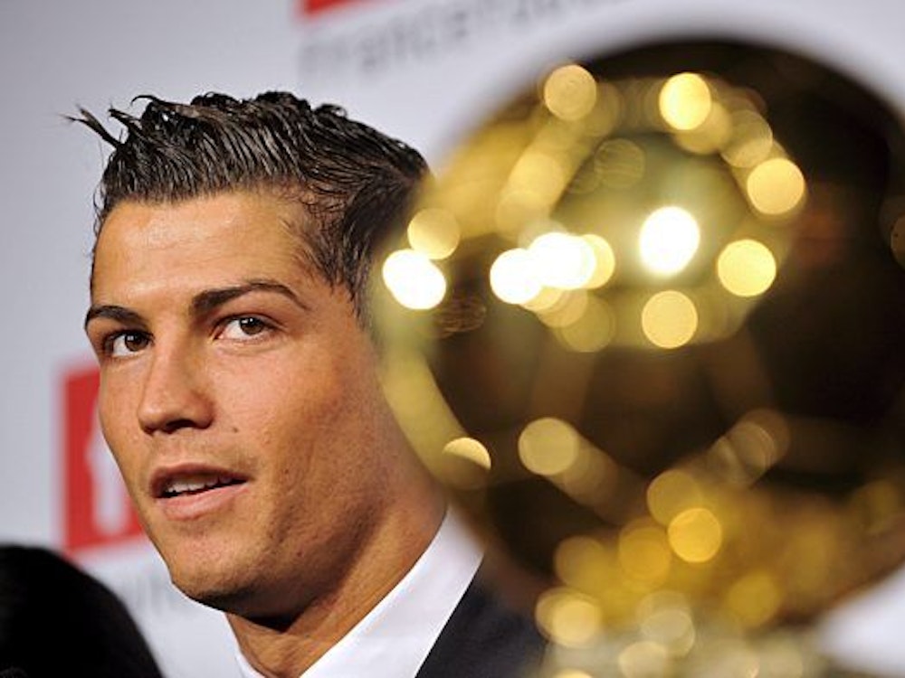 Ronaldo sitzt neben dem Ballon d’Or und beantwortet Fragen der Journalisten.