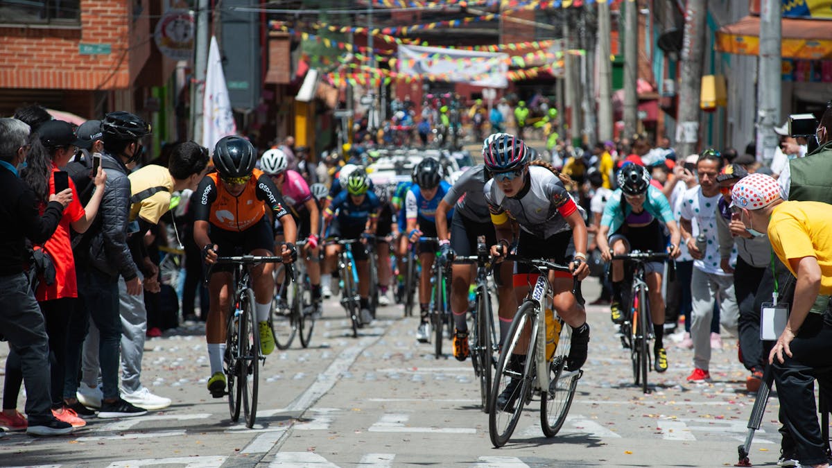 Die Rad-Profis kämpfen sich bei der&nbsp;Vuelta a Colombia auf einer schmalen Gasse den Berg hoch – Fans feuern von allen Seiten an.