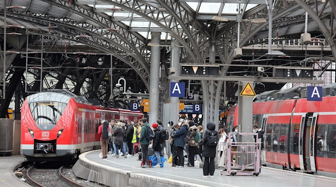 Am Kölner Hauptbahnhof fährt ein roter Zug der Deutschen Bahn ein.