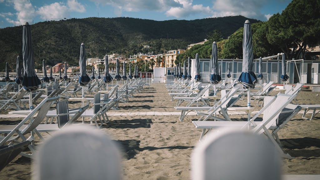 Liegestühle und Sonnenschirme stehen an einem Strand in Italien (Foto vom Mai 2020).