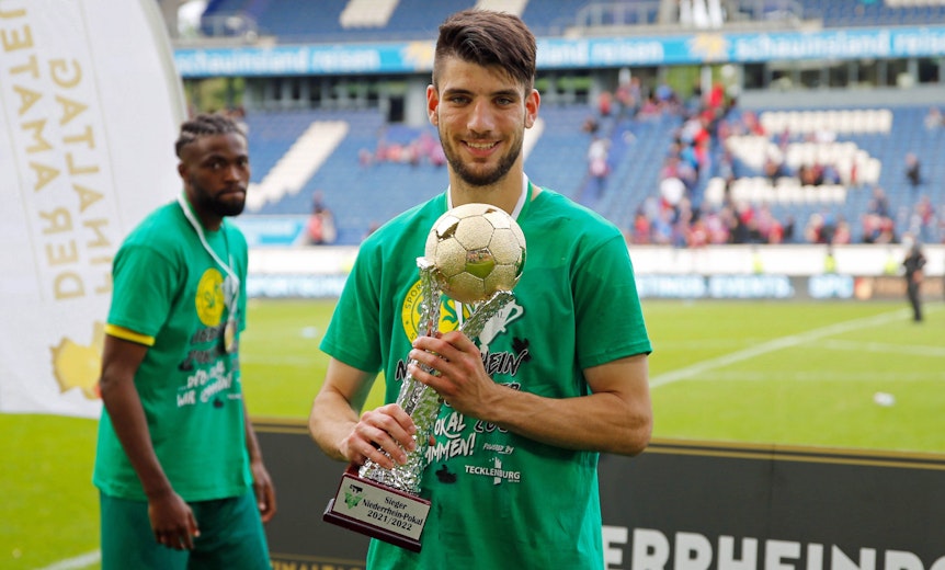 Er wechselt zu Borussia Mönchengladbach: Cagatay Kader, hier zu sehen am 21. Mai 2022 mit dem Niederrheinpokal in Duisburg, kommt vom SV Straelen in den Borussia-Park. Kader hält den Pokal in den Händen und lächelt in die Kamera.