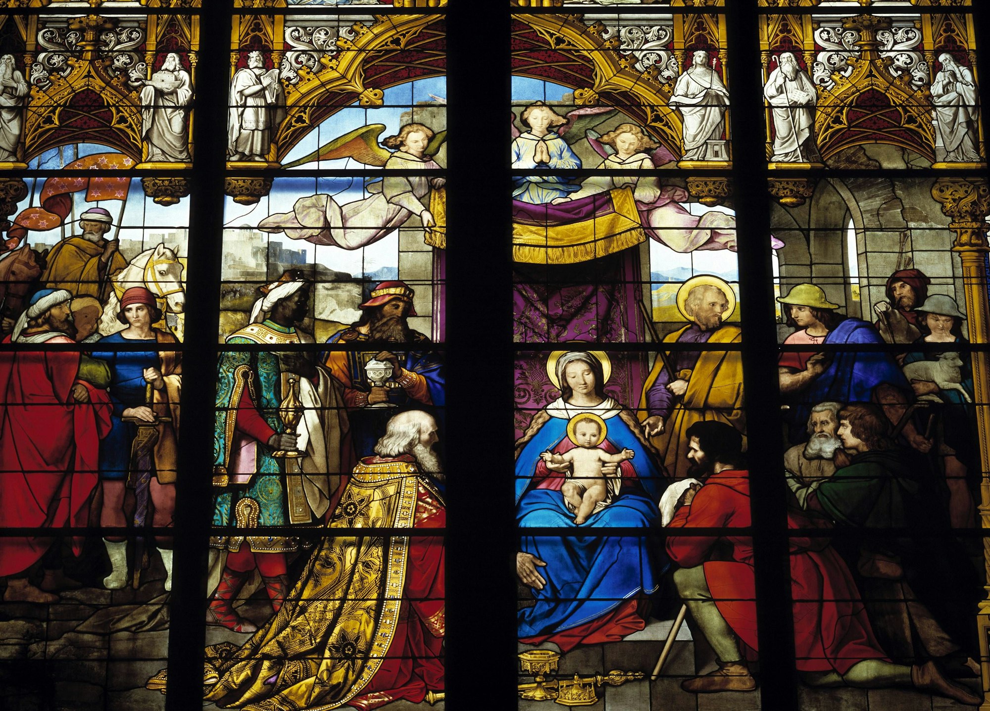 Ein bunt bemaltes Glasfenster im Kölner Dom, das die Ankunft der heiligen drei Könige darstellt.