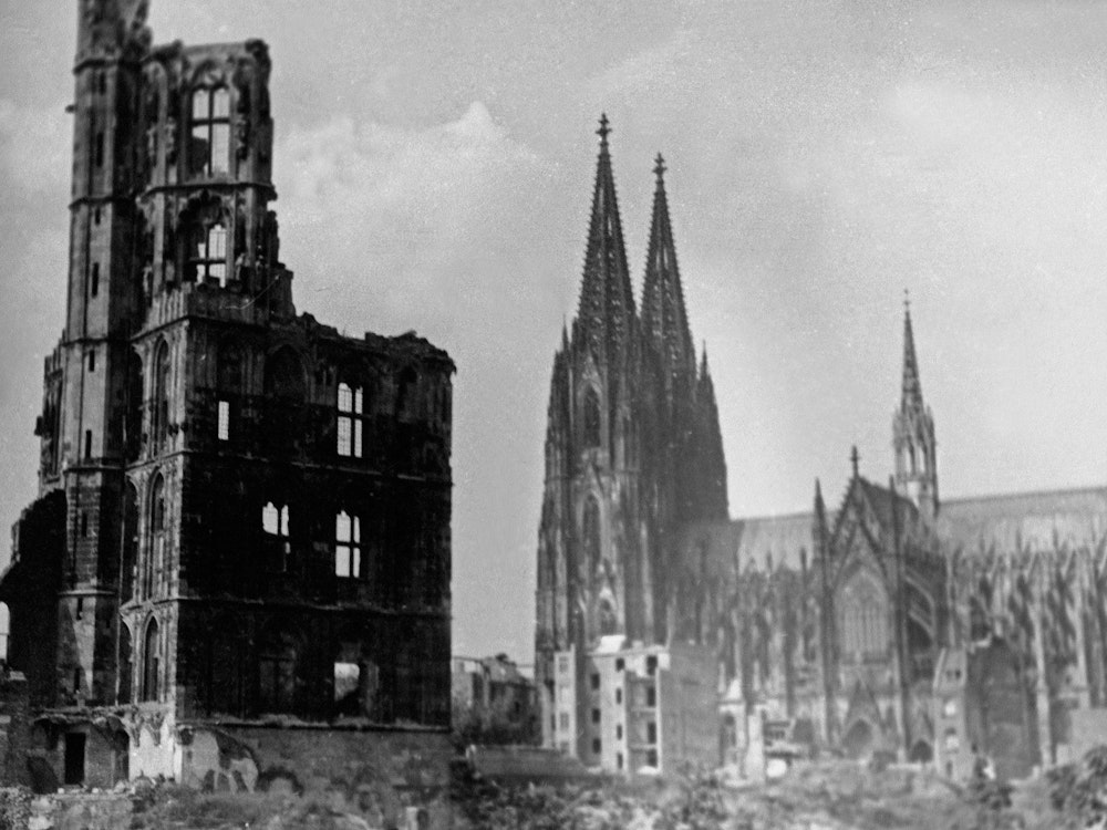 Der ausgebombte Turm vom historischen Rathaus in Köln mit dem verhältnismäßig intakten Dom.