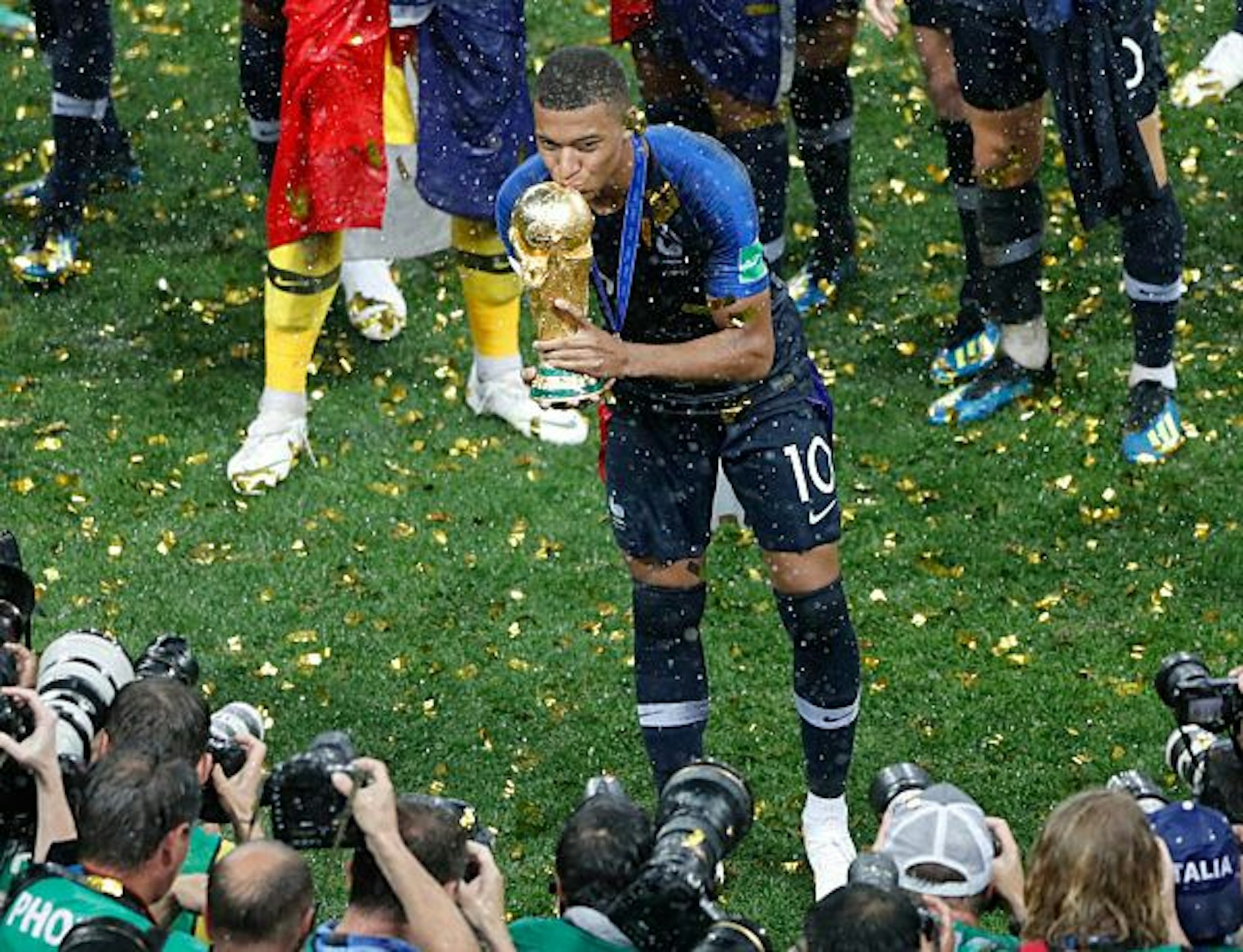 Mbappé küsst vor den Fotografen die gewonnene Weltmeisterschaftstrophäe.