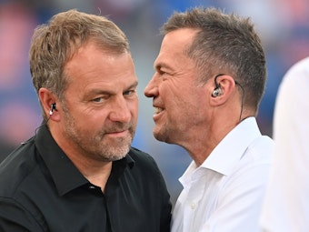 Hansi Flick unterhält sich mit Lothar Matthäus am Spielfeldrand.