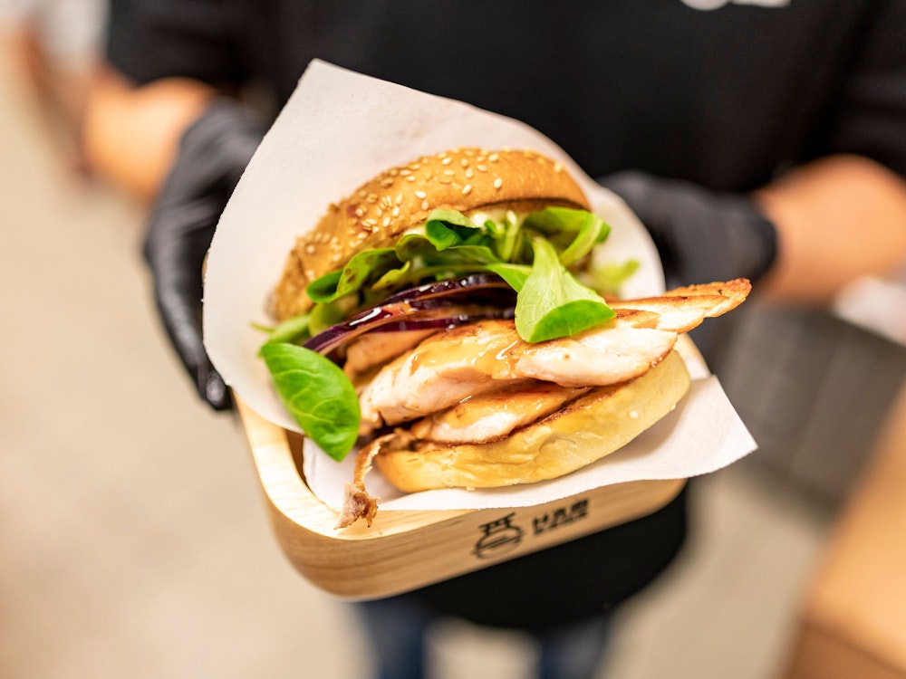 Der neue Spicysalmon Burger mit frischgebratenem Lachsfilet und Feldsalat im Burgerladen „Hambaga“ am Neumarkt.
