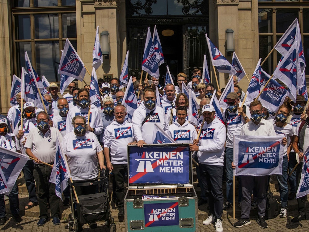 Das Bild vom 10. Juni 2022 zeigt die Menschen mit Schildern und Fahnen, welche mit dem Kampagnen-Motto „Keinen Meter mehr“ bedruckt sind.