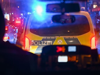 Sicht auf ein Polizeiauto mit Blaulicht bei einem Einsatz in der Kölner Innenstadt.