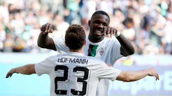 Gladbach-Stürmer Marcus Thuram jubelt mit Team-Kollege Jonas Hofmann über einen Treffer im Bundesliga-Duell gegen die TSG Hoffenheim am 14. Mai 2022 im Borussia-Park. Die beiden Borussen umarmen sich.
