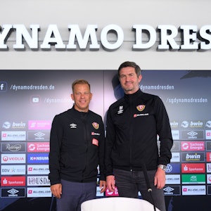 Markus Anfang (l), neuer Trainer des Drittligisten SG Dynamo Dresden, steht nach seiner Vorstellung in der AOK PLUS Walter-Fritzsch-Akademie auf dem Podium neben Ralf Becker.