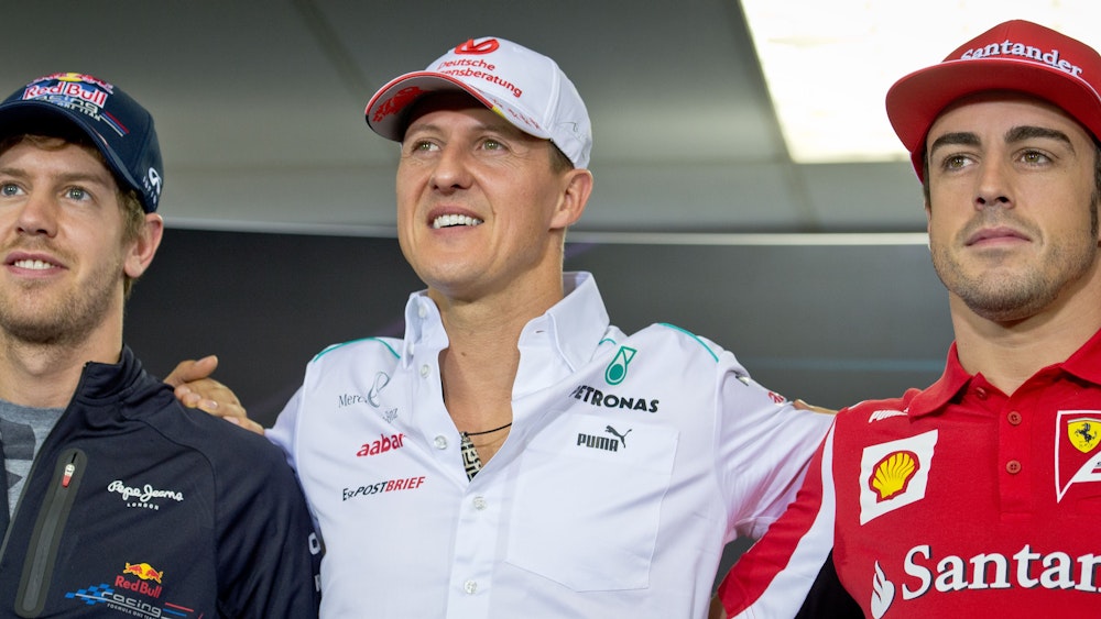 Sebastian Vettel (links), Michael Schumacher (Mitte), und Fernando Alonso posieren nach einer Pressekonferenz für ein Foto.