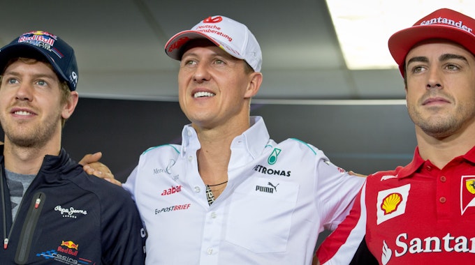 Sebastian Vettel (links), Michael Schumacher (Mitte), und Fernando Alonso posieren nach einer Pressekonferenz für ein Foto.