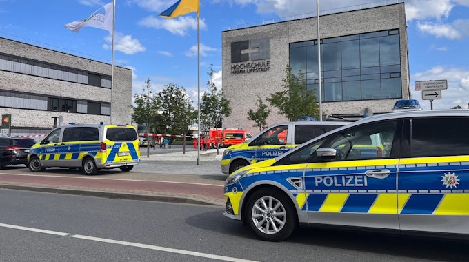 Einsatzfahrzeuge der Polizei stehen vor dem Gebäude der Hochschule Hamm-Lippstadt. An der Hochschule Hamm-Lippstadt hat ein 34-jähriger Mann mit einem Messer mehrere Menschen angegriffen und vier Personen verletzt, einige von ihnen schwer. Er wurde von Studenten überwältigt und festgehalten, bis Polizisten ihn festnahmen.