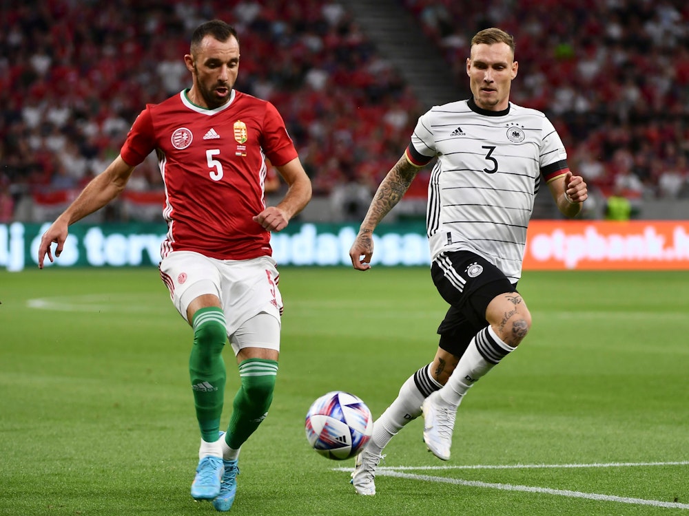 Hungary's Attila Fiola, left, duels for the ball with Germany's David Raum during the UEFA Nations League soccer match between Hungary and Germany at Puskas Arena in Budapest, Hungary, Saturday, June 11, 2022. (AP Photo/Anna Szilagyi)