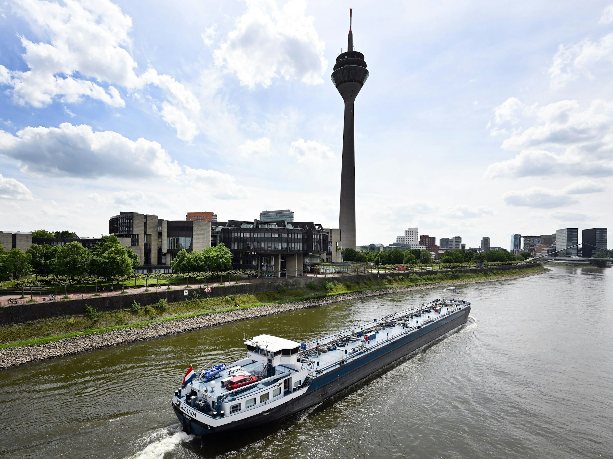 Ein Frachtschiff fährt auf dem Rhein an Düsseldorf vorbei. Im Hintergrund ist der Fernsehturm zu sehen.