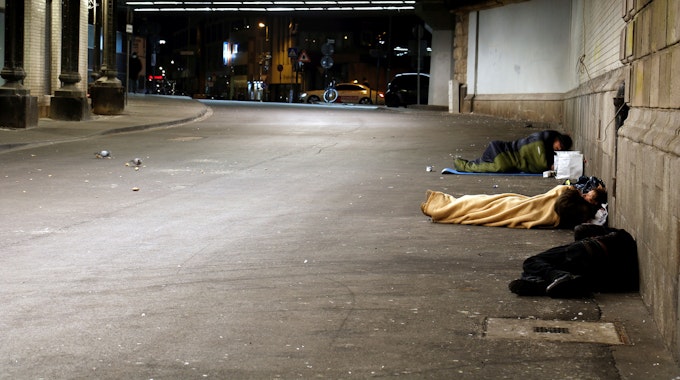 Obdachlose in Schlafsäcken in einer Unterführung.