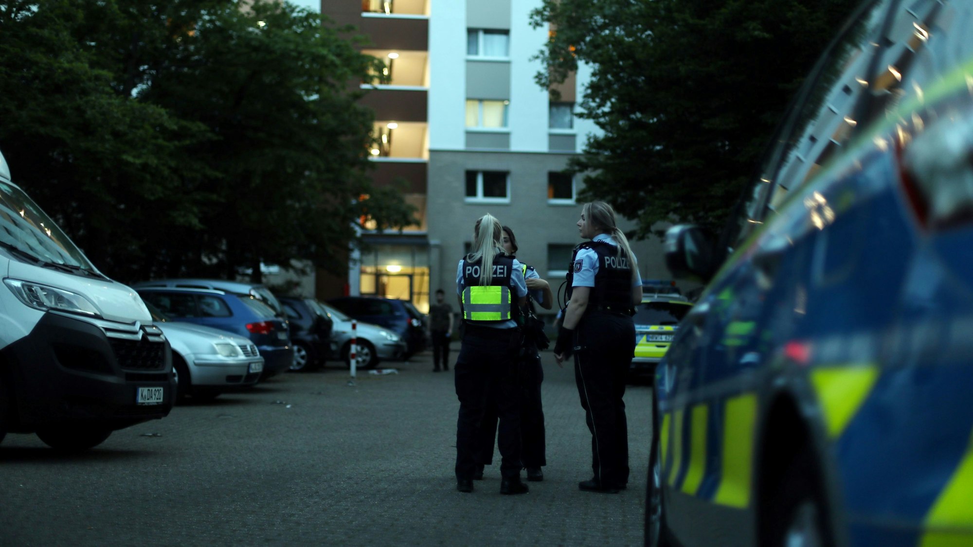 Beamte der Polizei Köln bei Ermittlungen vor ihrem Dienstwagen