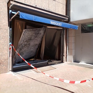 Das Schaufenster eines Juweliers auf der Düsseldorfer Kö ist völlig beschädigt. Die Polizei hat den Bereich davor mit Flatterband abgesperrt.