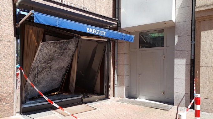 Das Schaufenster eines Juweliers auf der Düsseldorfer Kö ist völlig beschädigt. Die Polizei hat den Bereich davor mit Flatterband abgesperrt.