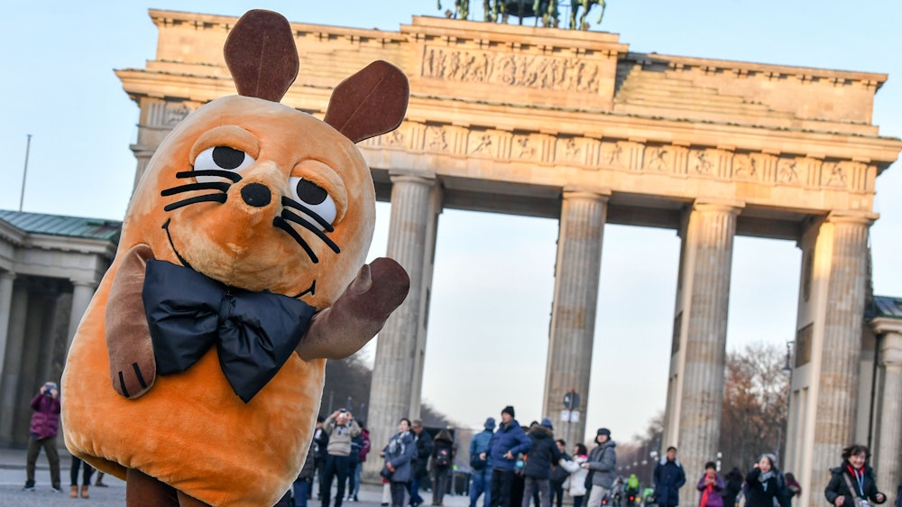 Die „Maus“ aus der ARD-Serie „Die Sendung mit der Maus“ steht vor dem Brandenburger Tor in Berlin.
