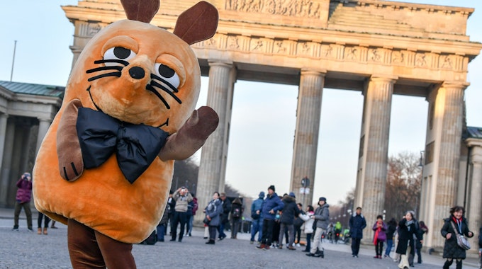 Die „Maus“ aus der ARD-Serie „Die Sendung mit der Maus“ steht vor dem Brandenburger Tor in Berlin.