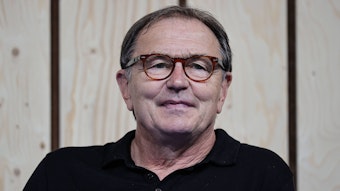 Ewald Lienen, ehemaliger Spieler und -trainer von Borussia Mönchengladbach am 28. August 2021 bei einer Podiumsdiskussion auf der Düsseldorfer Messe „Caravan Salon“ seelig lächelnd.