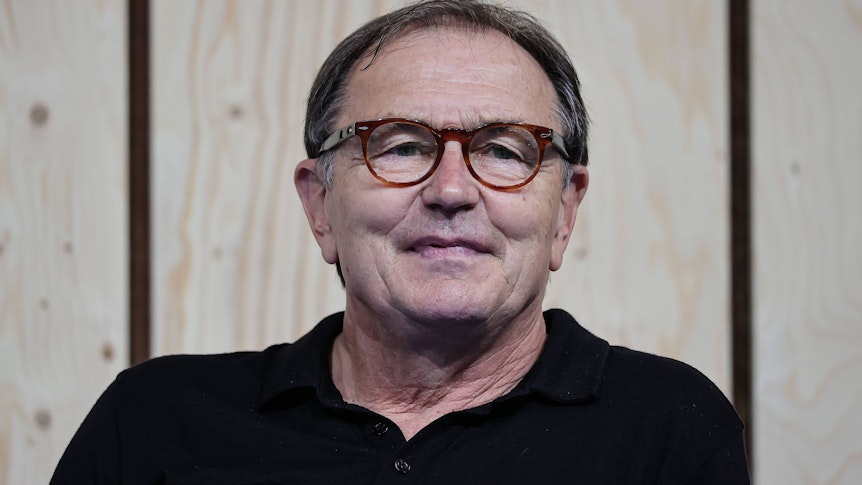 Ewald Lienen, ehemaliger Spieler und -trainer von Borussia Mönchengladbach am 28. August 2021 bei einer Podiumsdiskussion auf der Düsseldorfer Messe „Caravan Salon“ seelig lächelnd.