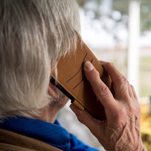 Eine ältere Dame telefoniert mit einem Smartphone.