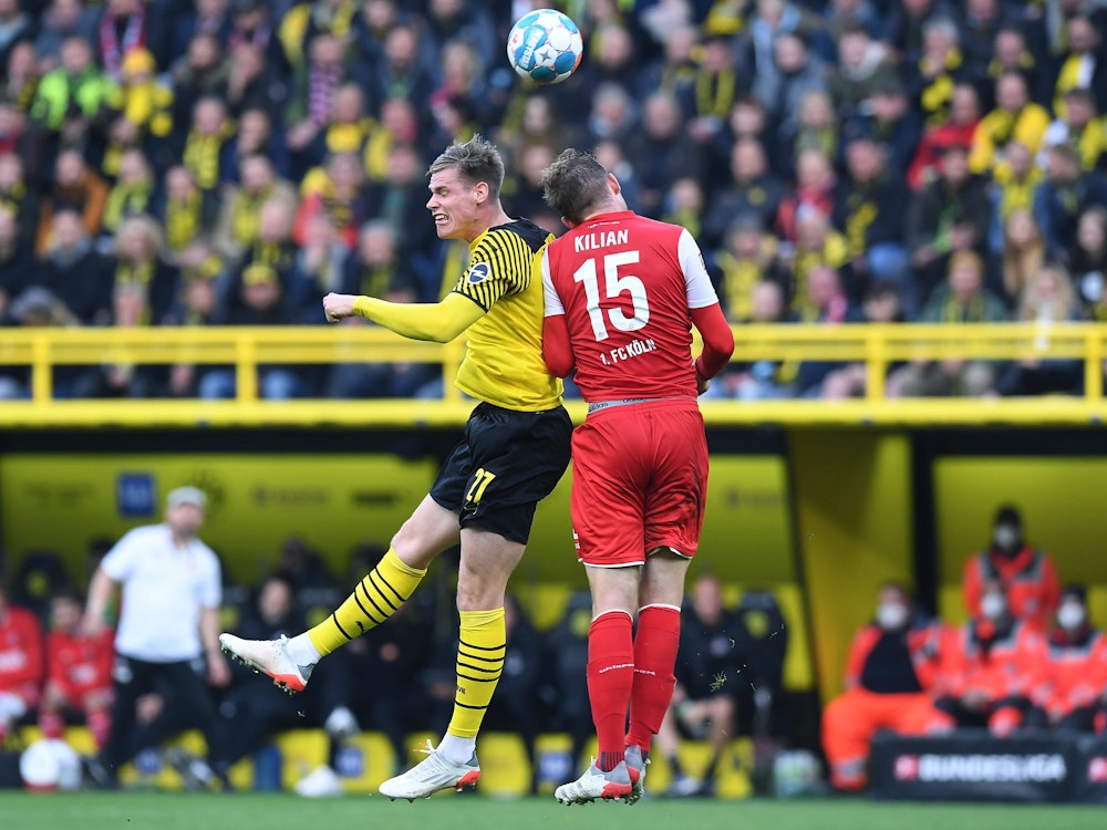 Steffen Tigges im Kopfballduell mit Luca Kilian beim Bundesliga-Duell zwischen Borussia Dortmund und dem 1. FC Köln.