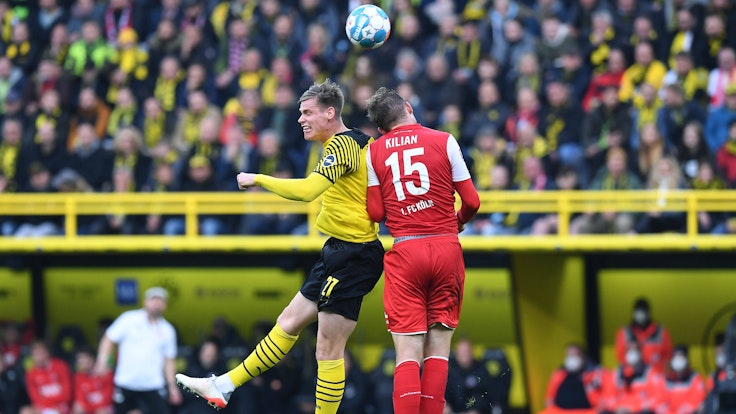 Steffen Tigges im Kopfballduell mit Luca Kilian beim Bundesliga-Duell zwischen Borussia Dortmund und dem 1. FC Köln.