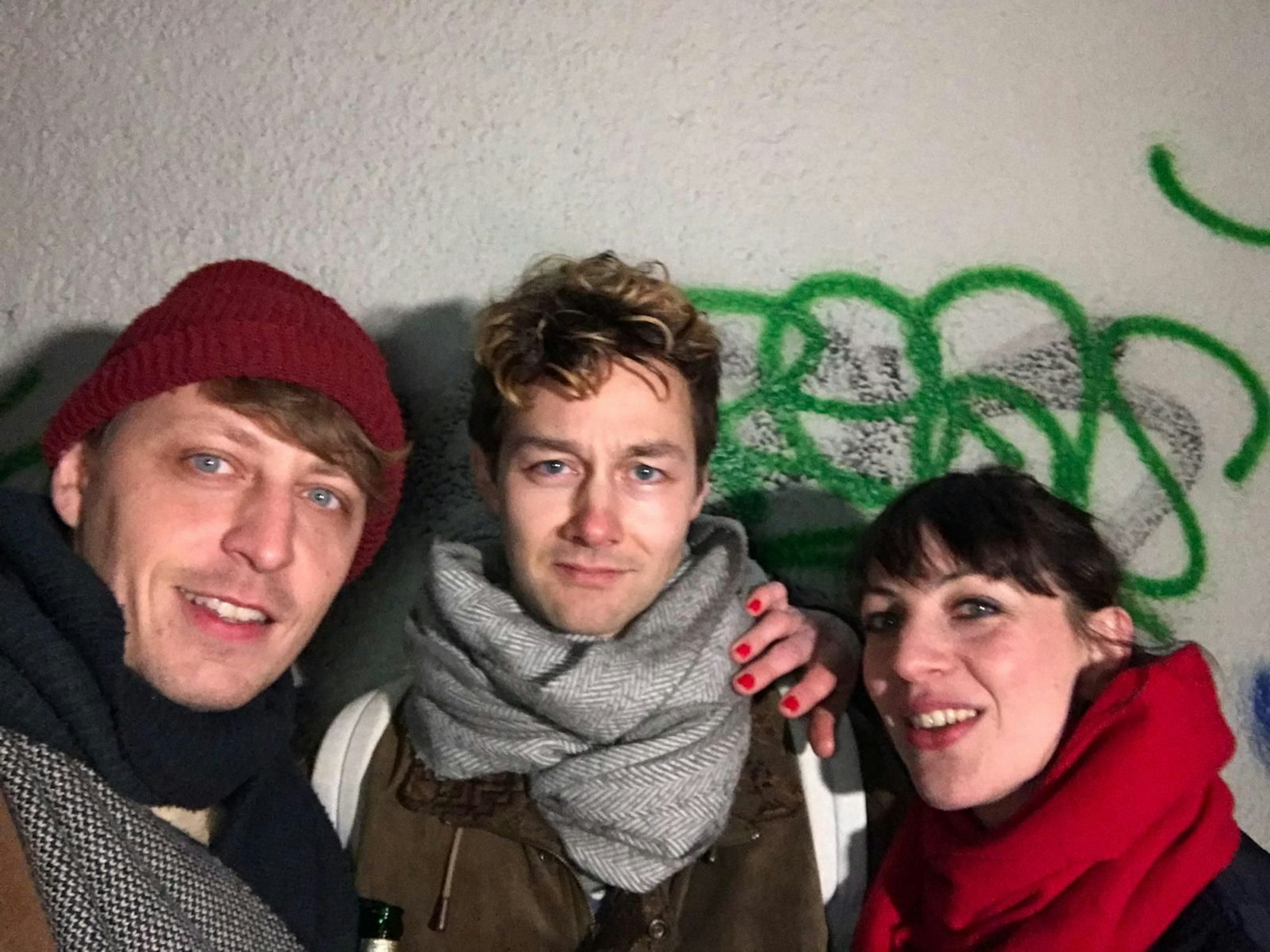 Ein Selfie der Schauspieler Simon Rußig, Tim-Fabian Hoffmann und Oona von Maydell vor einer Wand.