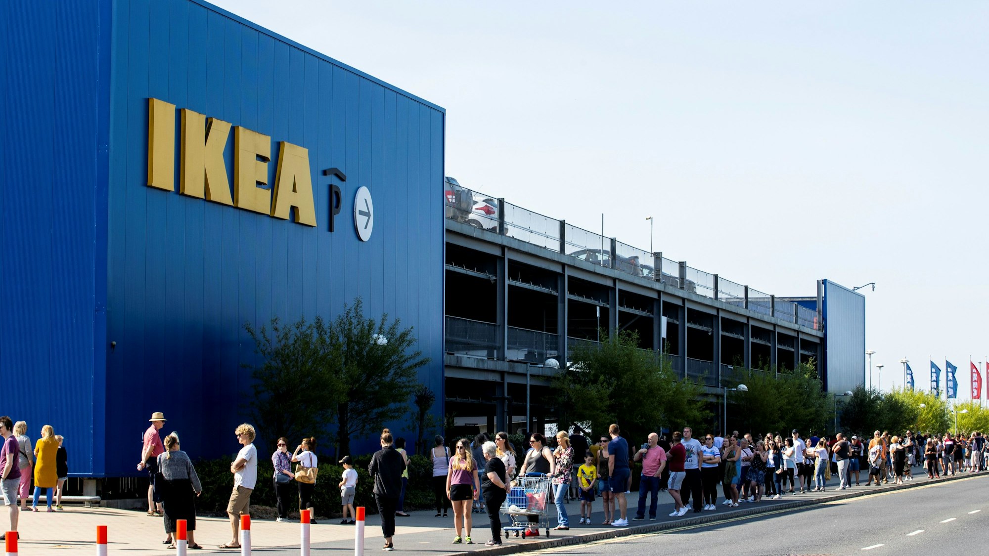 Zahlreiche Menschen stehen vor einem Ikea-Laden, der nach der zwischenzeitlichen Schließung aufgrund der Corona-Krise heute wiedereröffnet hat, in einer langen Schlange neben dem Ikea-Gebäude und warten auf ihren Einlass.