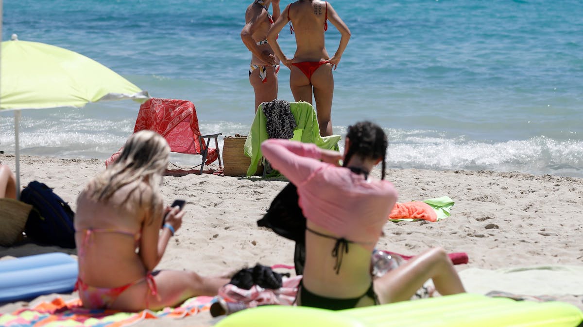 Frauen sonnen sich am 11. Juni am Strand von Palmanova auf Mallorca. Eine Hitzewelle hat die Ferieninsel im Griff, hier wird nun vom spanischen Wetterdienst die Warnstufe erhöht.