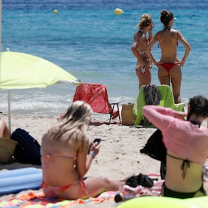 Frauen sonnen sich am 11. Juni am Strand von Palmanova auf Mallorca. Eine Hitzewelle hat die Ferieninsel im Griff, hier wird nun vom spanischen Wetterdienst die Warnstufe erhöht.