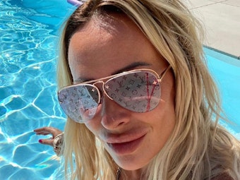 Cora Schumacher sitzt im Pool und grinst für ein Selfie in die Kamera.
