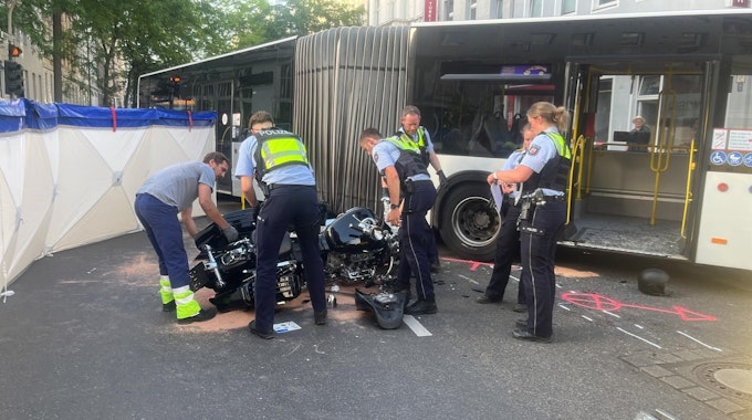 Einsatzkräfte der Polizei am Unfallort in Köln-Nippes. Dort kollidierte ein Motorradfahrer mit einem KVB-Bus.