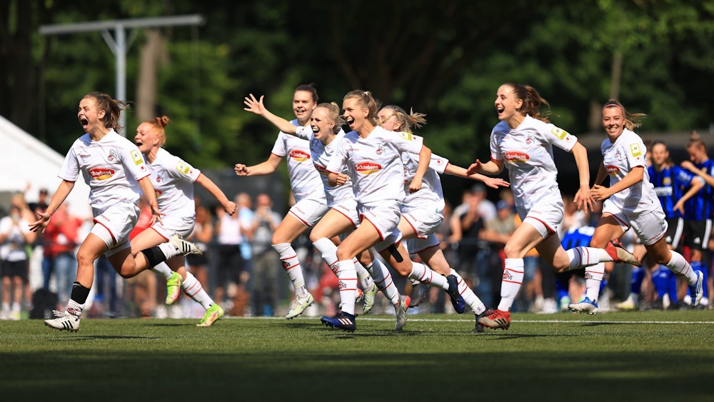 Die Spielerinnen der U20 des 1. FC Köln laufen jubelnd über den Rasen