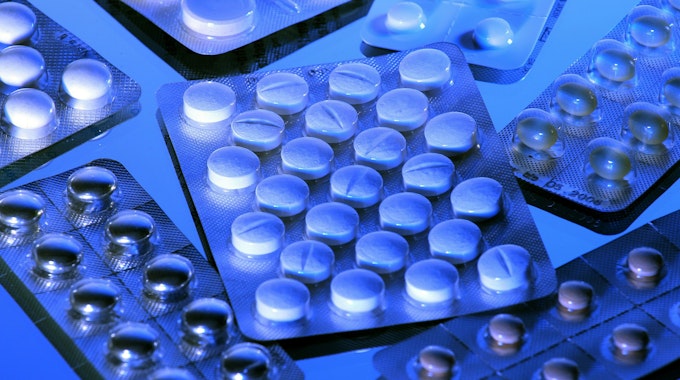 Auf einem Tisch liegen mehrere unterschiedliche verpackte Tabletten.