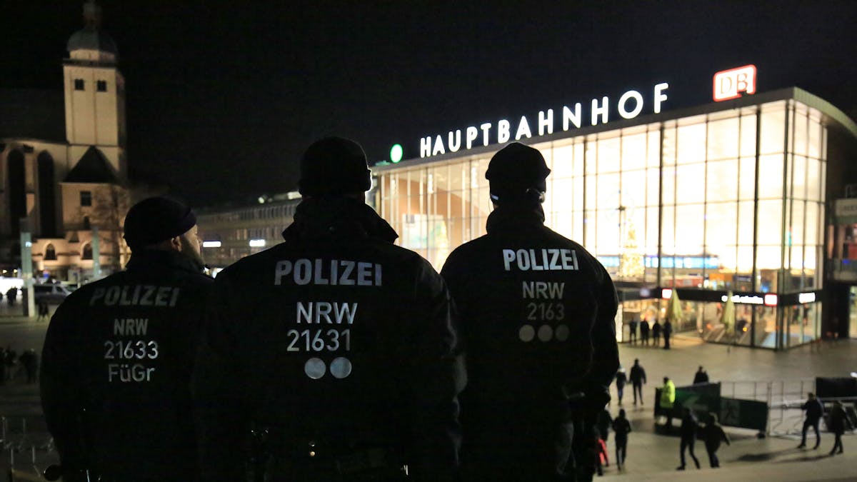 Drei Polizisten stehen in Uniform am 31. Dezember 2016 in Köln (Nordrhein-Westfalen) vor dem Hauptbahnhof.