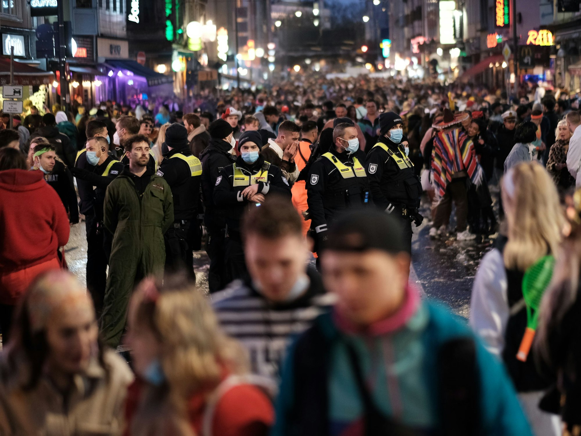 Polizei und Ordnungsamt steht an Weiberfastnacht mittendrin in einer großen Menschenmasse auf der Zülpicher Straße in Köln.