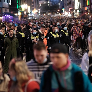 Polizei und Ordnungsamt steht an Weiberfastnacht mittendrin in einer großen Menschenmasse auf der Zülpicher Straße in Köln.