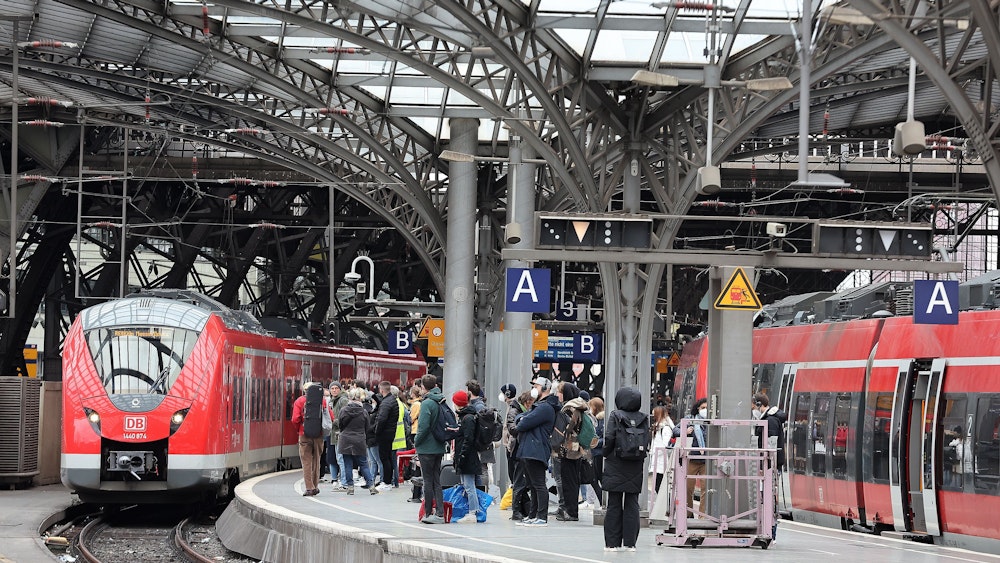 Zahlreiche Menschen warten auf einem Bahnsteig im Kölner Hauptbahnhof.