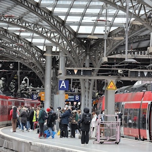 Zahlreiche Menschen warten auf einem Bahnsteig im Kölner Hauptbahnhof.