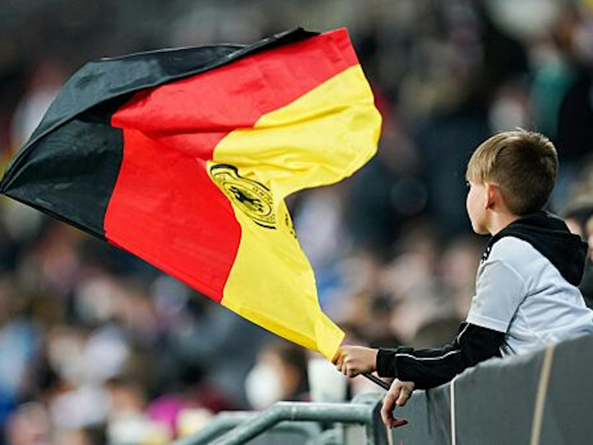 Ein junger Fan schwenkt vor dem Spiel eine Deutschlandfahne.