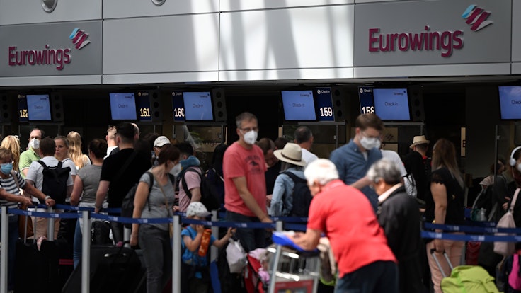Zahlreiche Passagiere stehen an den Eurowings-Schaltern im Flughafen Düsseldorf.