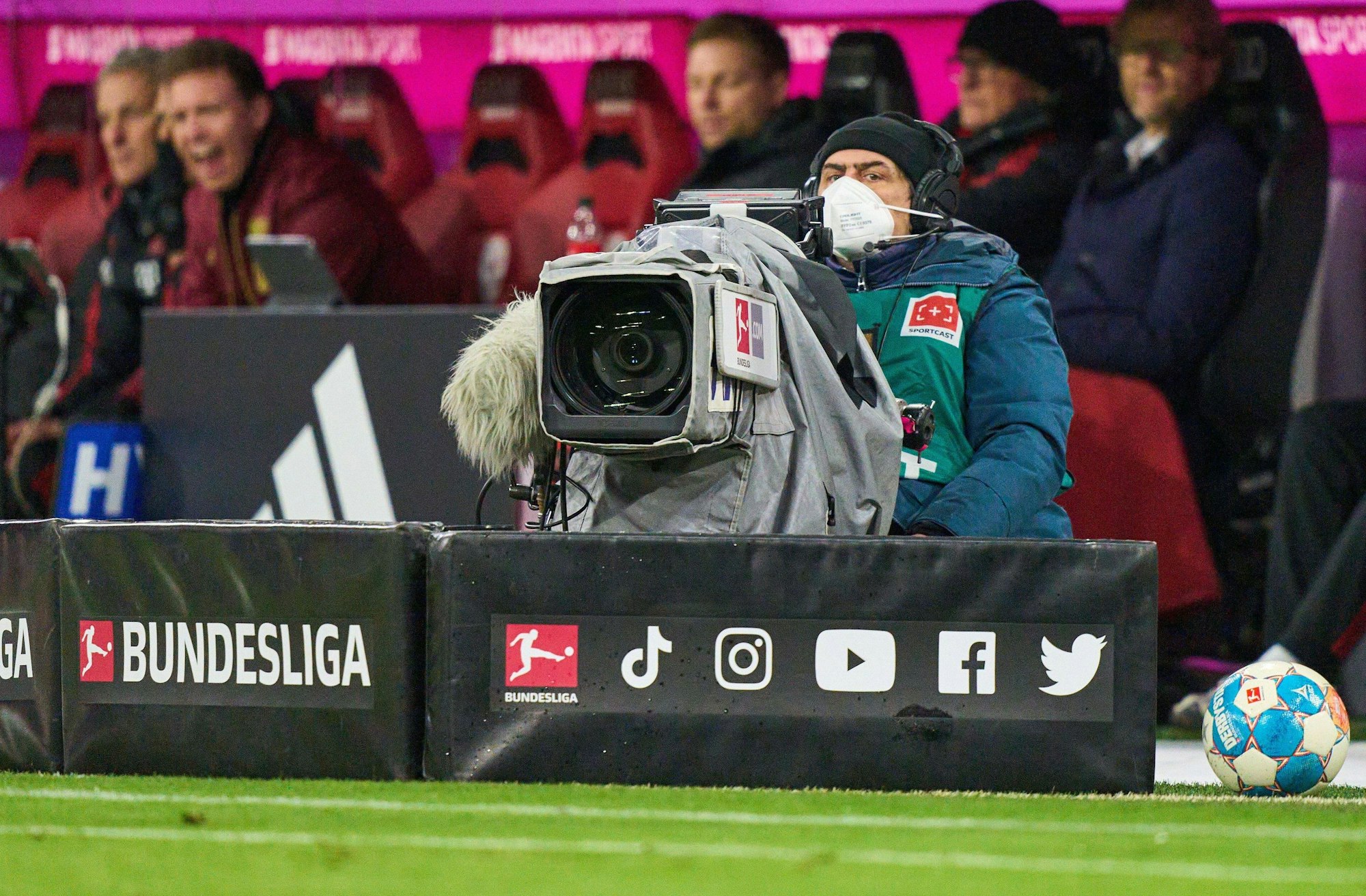 Ein Kameramann sitzt beim Bundesliga-Spiel gegen RB Leipzig vor der Bank des FC Bayern München