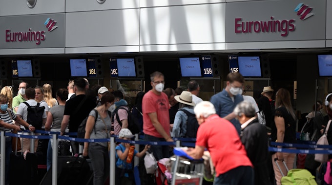 Lange Schlangen an den Check-in-Schaltern: Zahlreiche Passagiere warten am 21. Juni am Flughafen Düsseldorf darauf, bei Eurowings einchecken zu können.