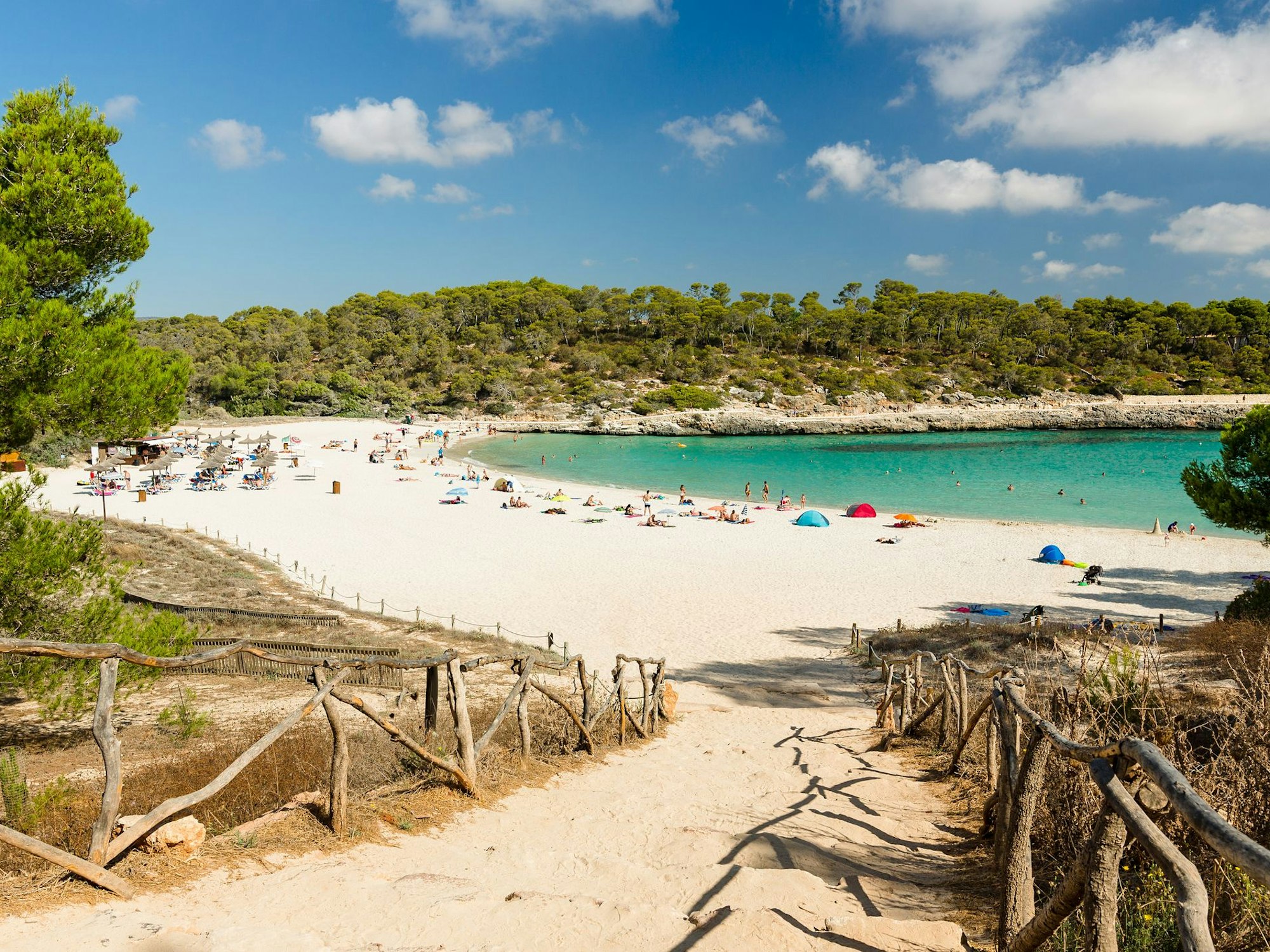 Die Cala Mondrago auf Mallorca mit Menschen am Strand vor dem Meer.